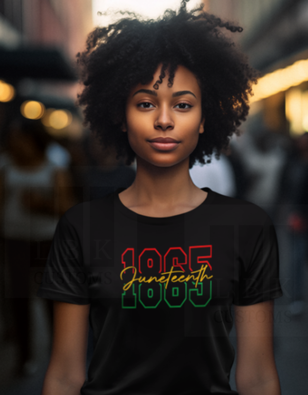 African American woman with black curly hair wearing a black shirt with Juneteenth 1865