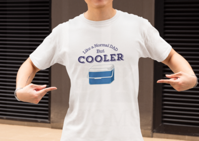 Man in white shirt with glasses pointing at his shirt