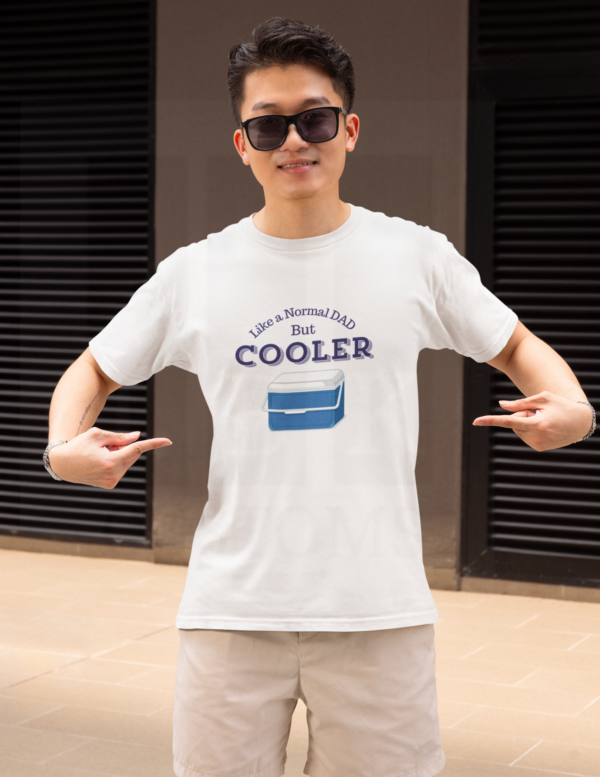 Man in white shirt with glasses pointing at his shirt