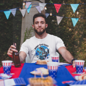 Man sitting at picnic table holding a beverage